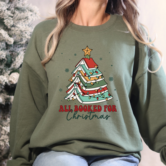 Person wearing a green sweatshirt with a Christmas tree design and text.