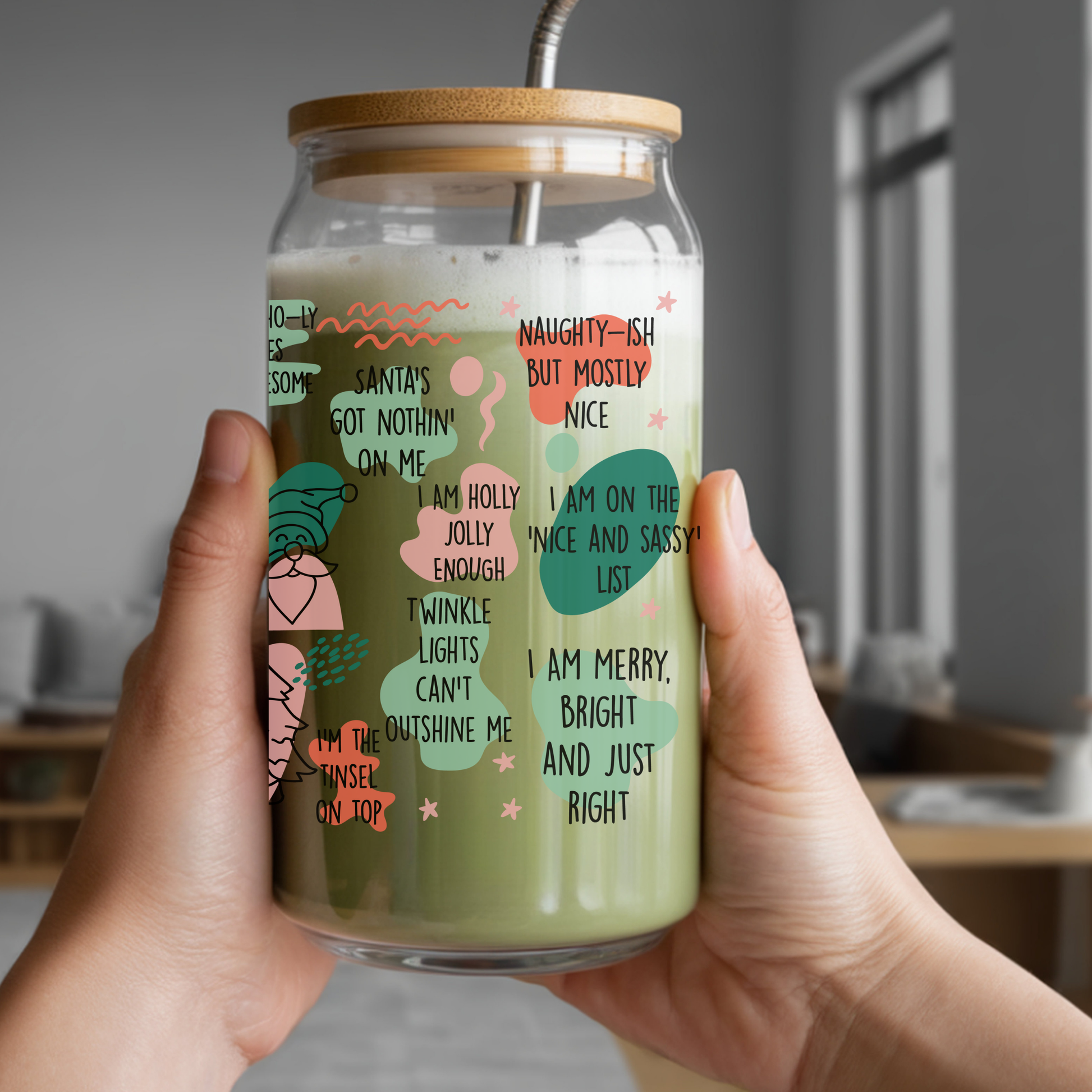 Hand holding a glass jar with a straw lid, featuring a colorful text design.