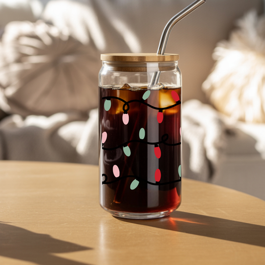 Glass tumbler with a wooden lid and metal straw on a wooden surface, containing a dark liquid with colorful lights.