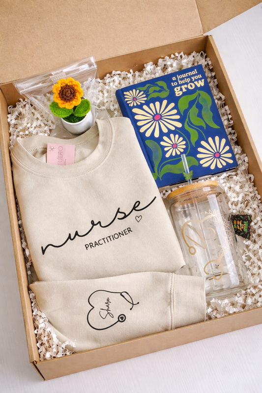 Gift box containing a 'nurse practitioner' shirt, a plant, a journal, and a tumbler.