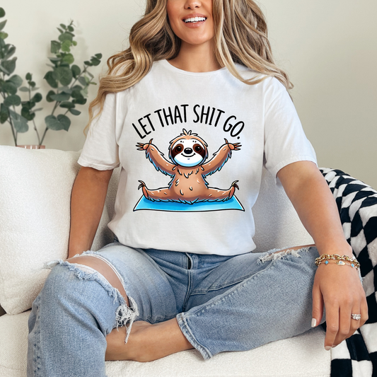 Person wearing a white t-shirt with a sloth graphic and text, sitting on a couch.