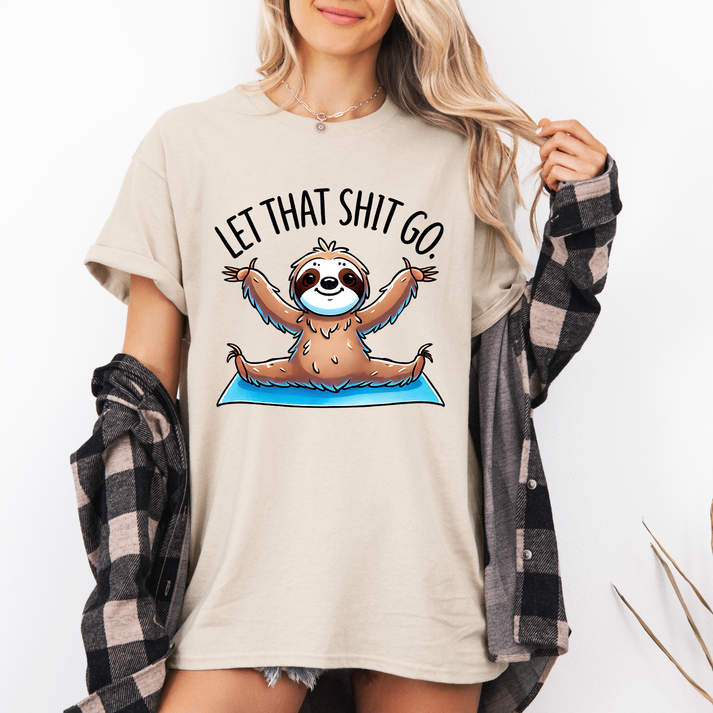 Person wearing a t-shirt with a sloth graphic and text 'Let That Shit Go' on a plain background