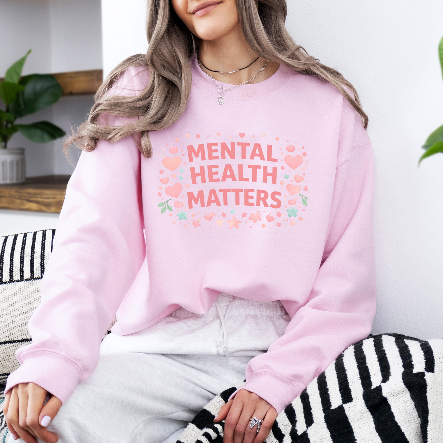 Person wearing a pink sweatshirt with 'Mental Health Matters' text and hearts.