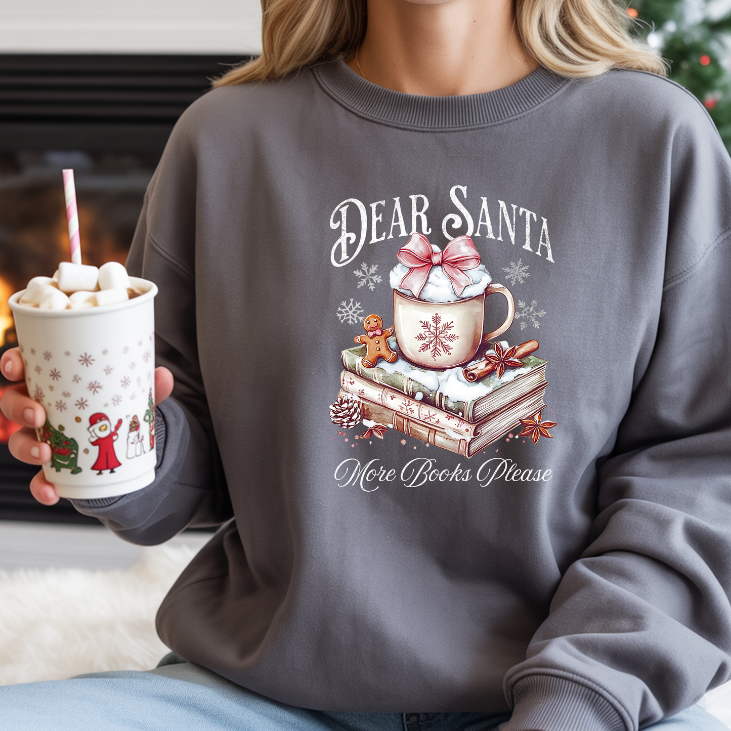 Person wearing a sweater with a Christmas design holding a hot chocolate cup.