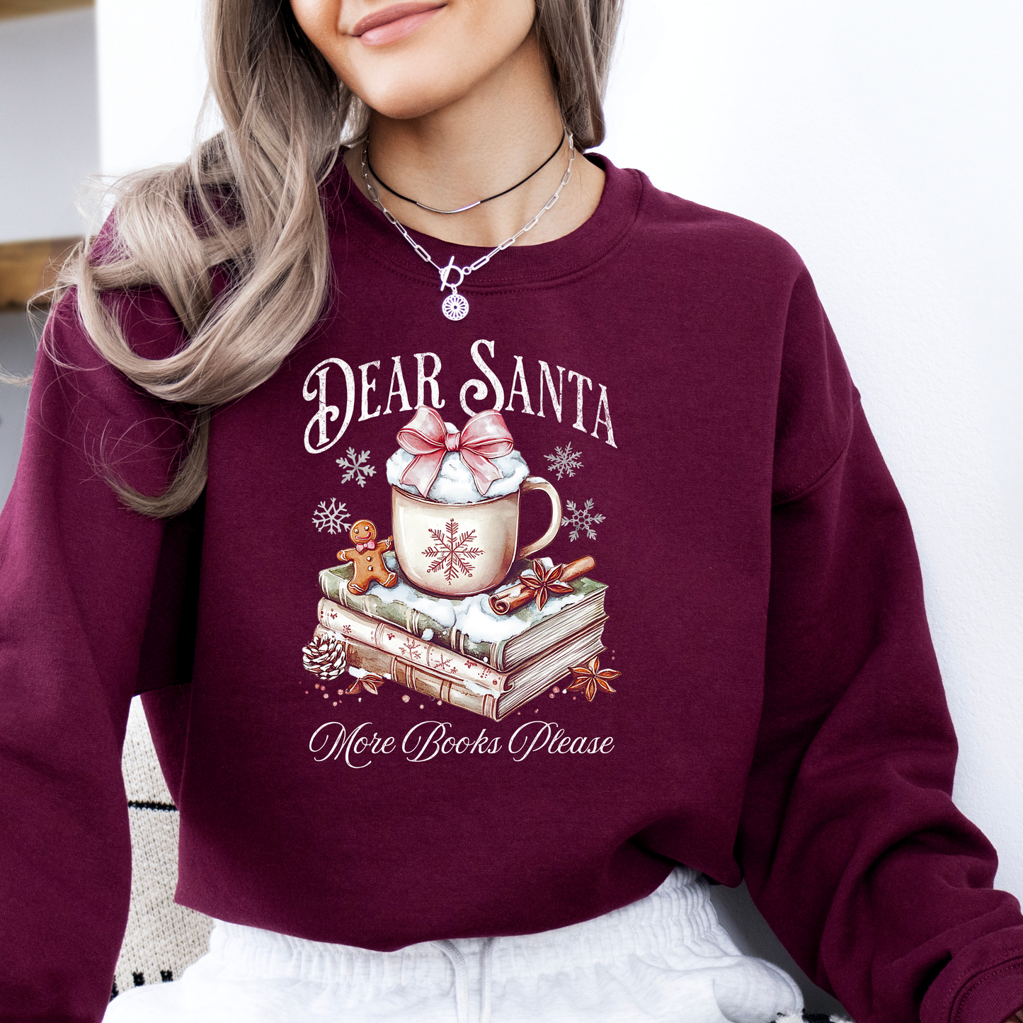 Maroon sweatshirt with 'Dear Santa, More Books Please' design featuring a mug of hot chocolate and books.
