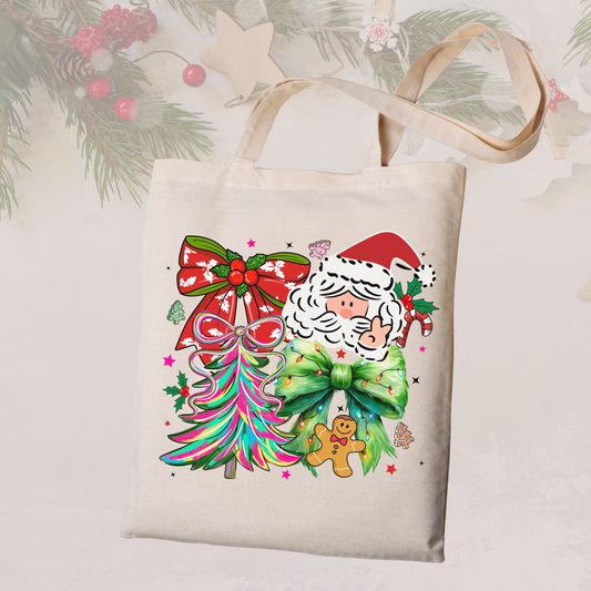 Tote bag with Christmas design featuring Santa Claus, trees, and a bow on a light background.