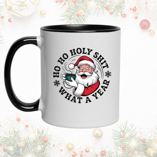 White mug with black interior and handle, featuring a Santa Claus graphic and text, against a festive background.