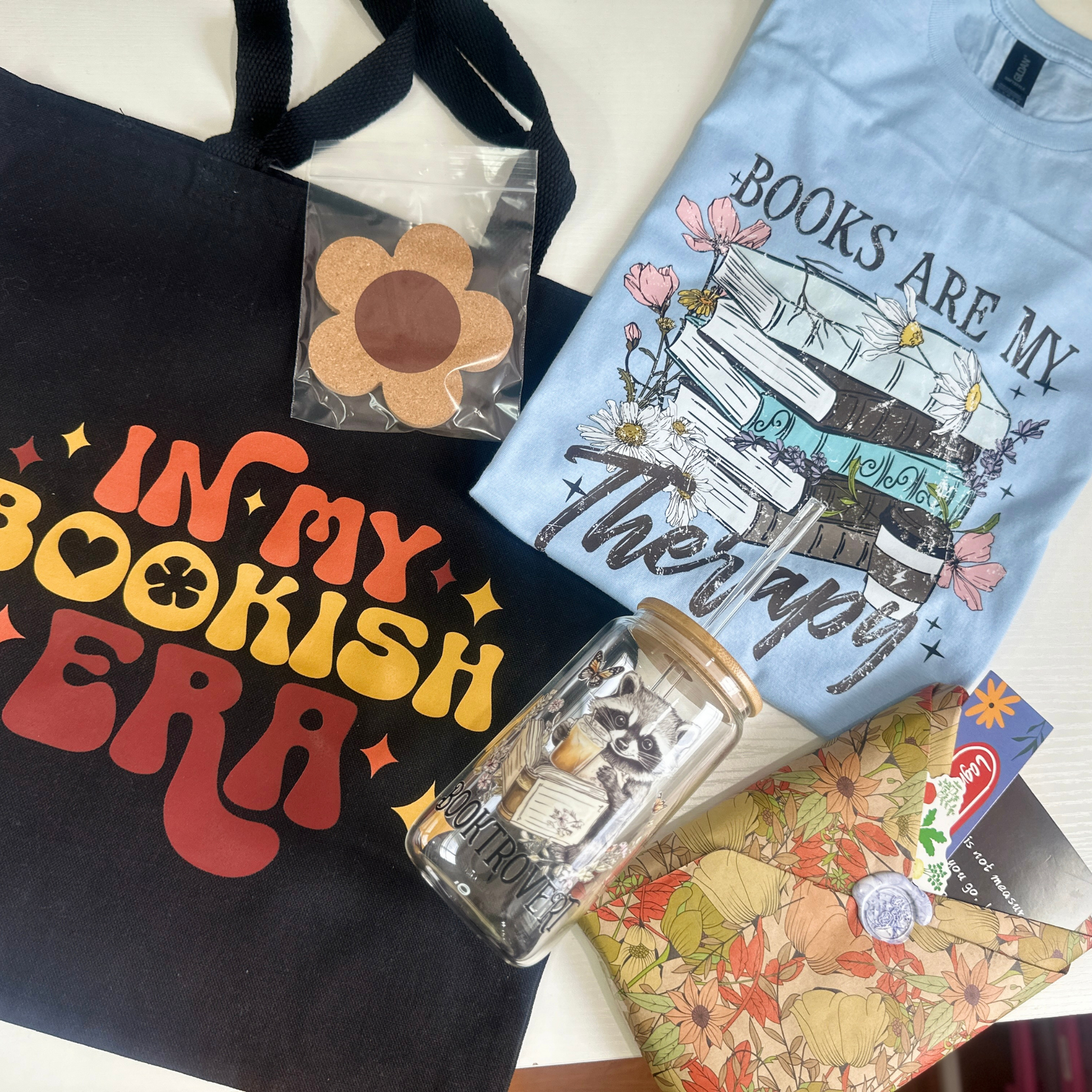 The Summer Bookish Bundle Includes:

-1 (one) Bookish T-Shirt&nbsp;

-1 Blind Book (you pick the genre!)

-1, 16oz Bookish Glass with lid and straw&nbsp;

- 1 Bookmark

-1 Coaster

-1 Tote Bag